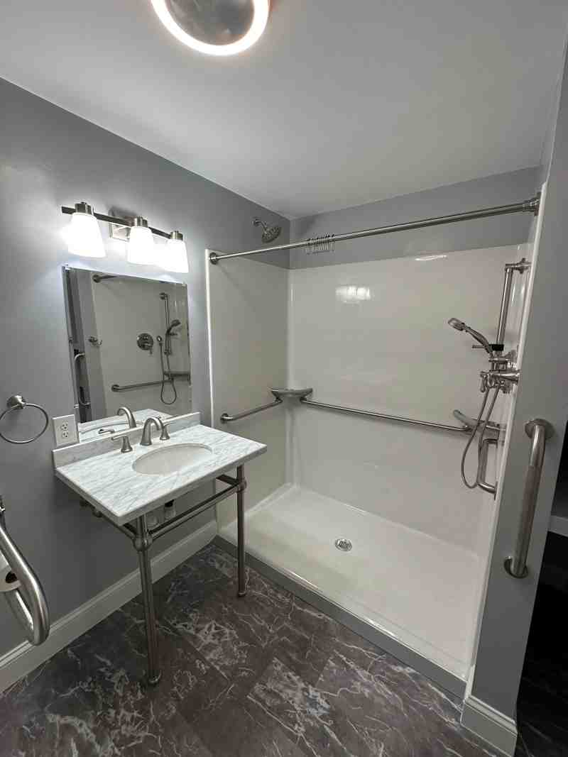 a modern walk-in shower with sleek grab bars and a built-in bench - bathroom remodeling companies in my area