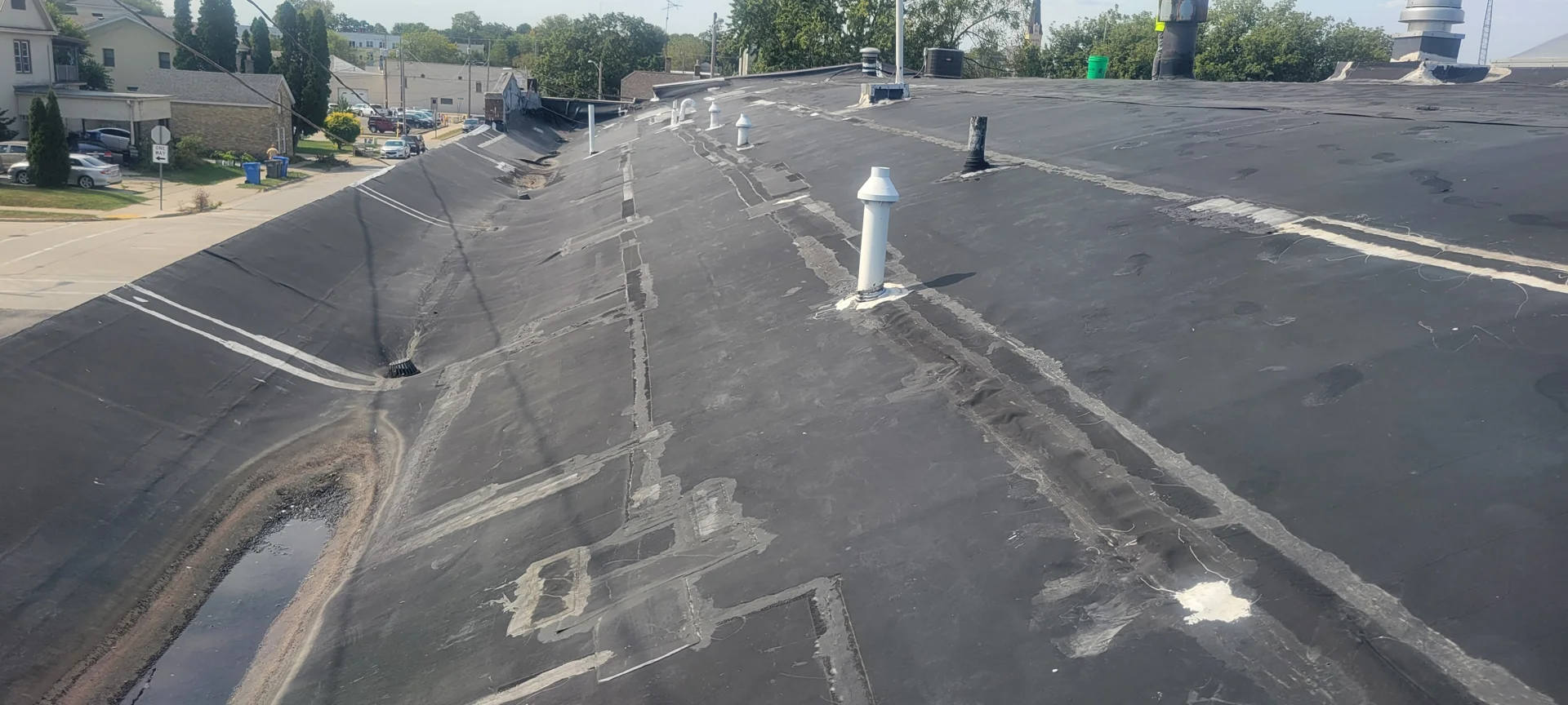 Professional roofing contractor cleaning an EPDM membrane before repair - epdm leak repair services Professional roofing contractor cleaning an EPDM membrane before repair - epdm leak repair services
