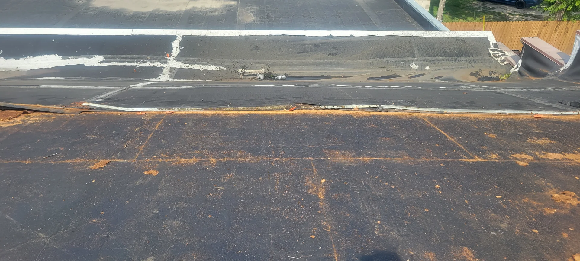 Commercial roofing technician inspecting EPDM membrane for UV damage and seam failure - EPDM roof restoration Rochester Commercial roofing technician inspecting EPDM membrane for UV damage and seam failure - EPDM roof restoration Rochester