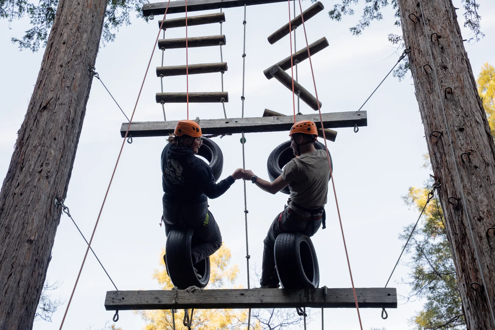 Corporate team members navigating a high ropes challenge course