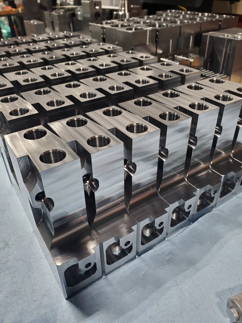 A selection of precision machined parts made from anodized aluminum, stainless steel, and high-performance PEEK plastic