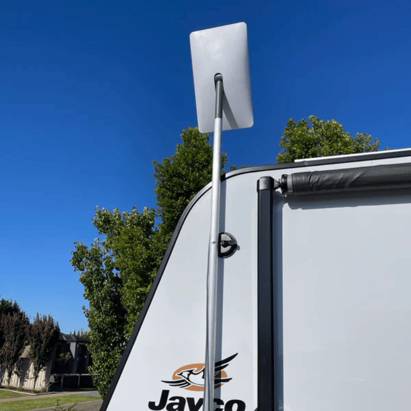 An RV parked in a scenic Australian landscape, with a Starlink dish mounted securely on its roof, connected to an internal DC power system. - starlink dc power supply
