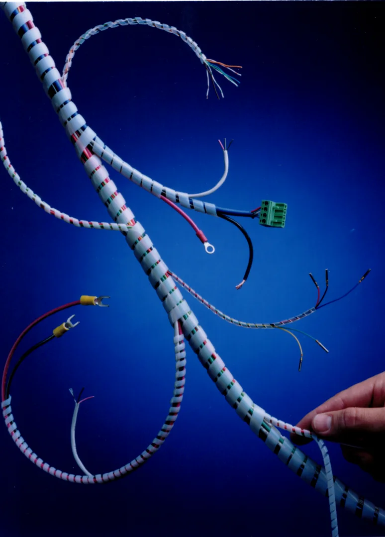 Technician manually wrapping a wire bundle with Heli-Tube® spiral wrap Technician manually wrapping a wire bundle with Heli-Tube® spiral wrap