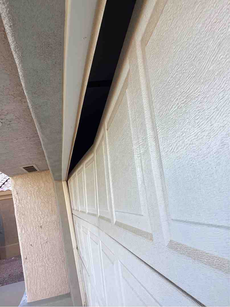 damaged garage door with visible wear and tear - garage door repairs in Anthem Arizona
