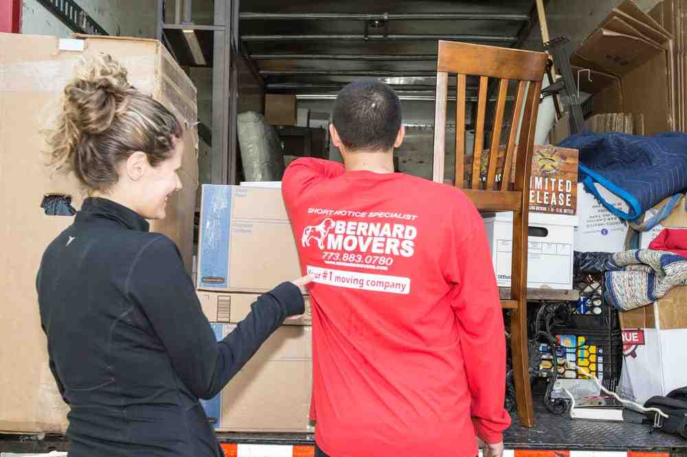 professional movers carefully loading a truck with office equipment - checklist for moving office locations