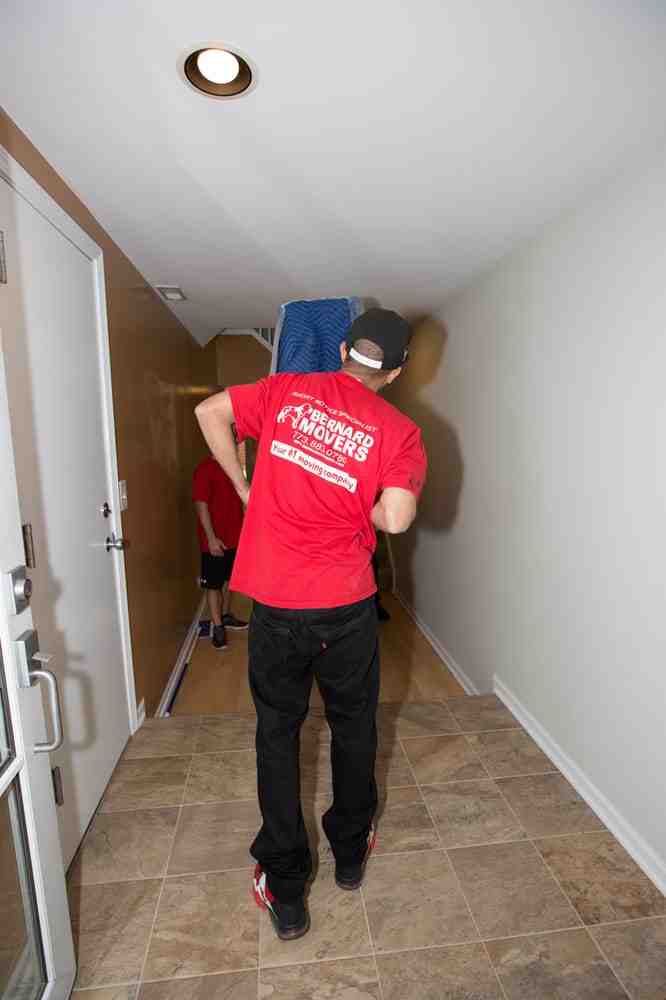 Bernard Movers' team professionally wrapping a large piece of furniture - Affordable movers Elmhurst Bernard Movers' team professionally wrapping a large piece of furniture - Affordable movers Elmhurst