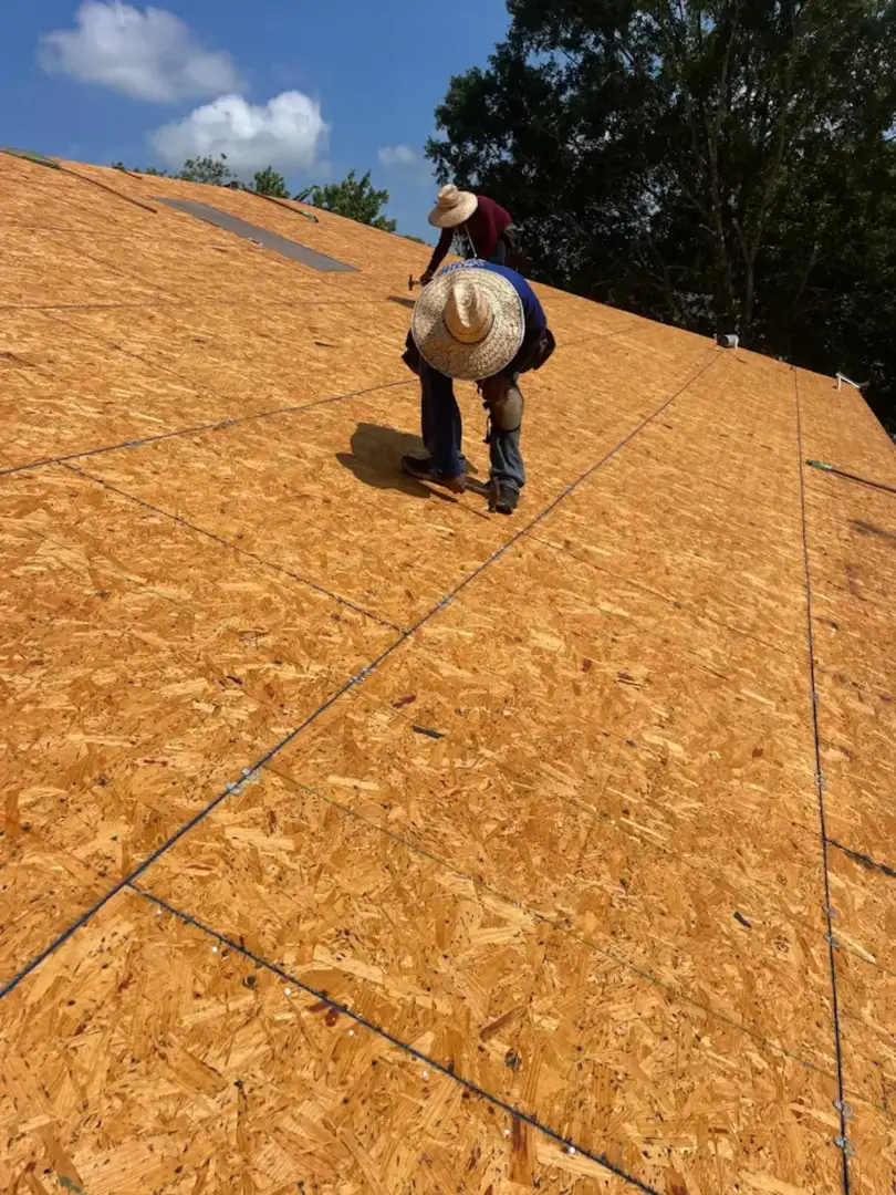 Professional roofing contractor inspecting a roof deck Professional roofing contractor inspecting a roof deck