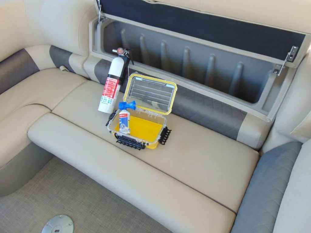 Safety equipment display including life jackets of various sizes and a fire extinguisher on a boat dock