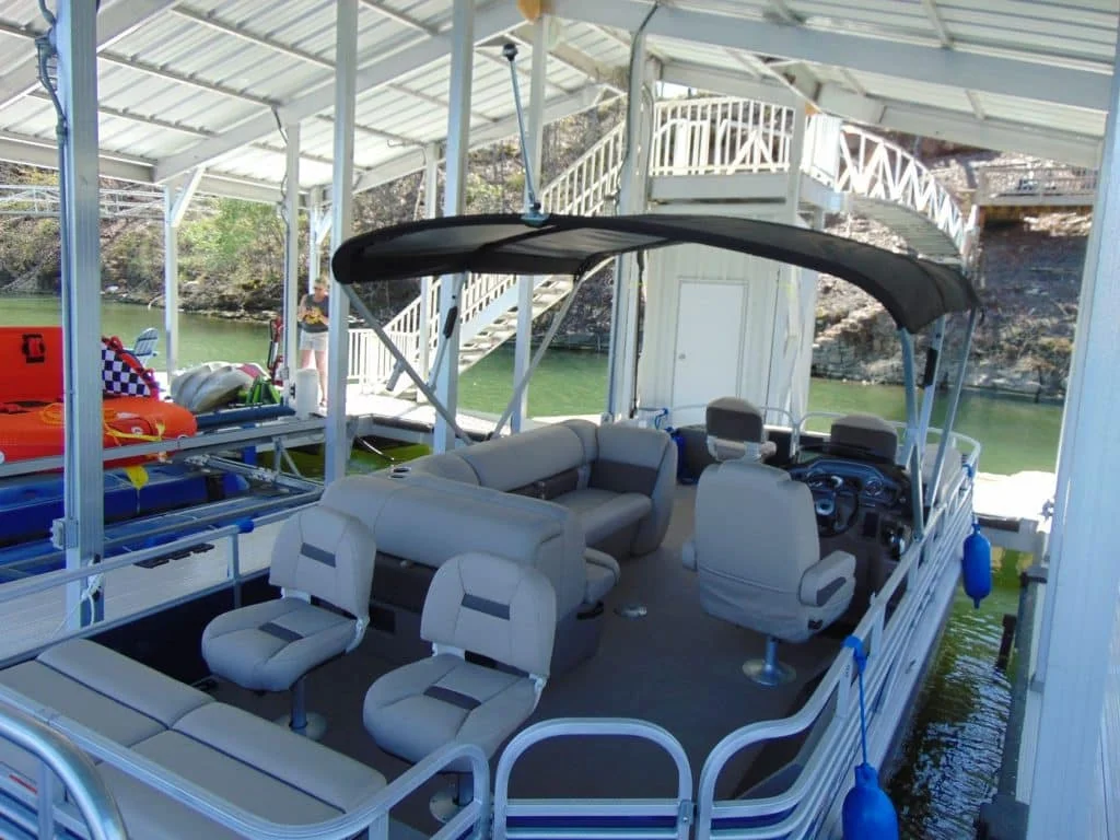 A serene lakefront view of Smith Lake with clear blue water and a private dock featuring a pontoon boat and a happy dog