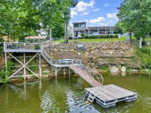 A beautiful view of a Smith Lake lakefront home with a private dock and a pontoon boat, reflecting the clear blue water