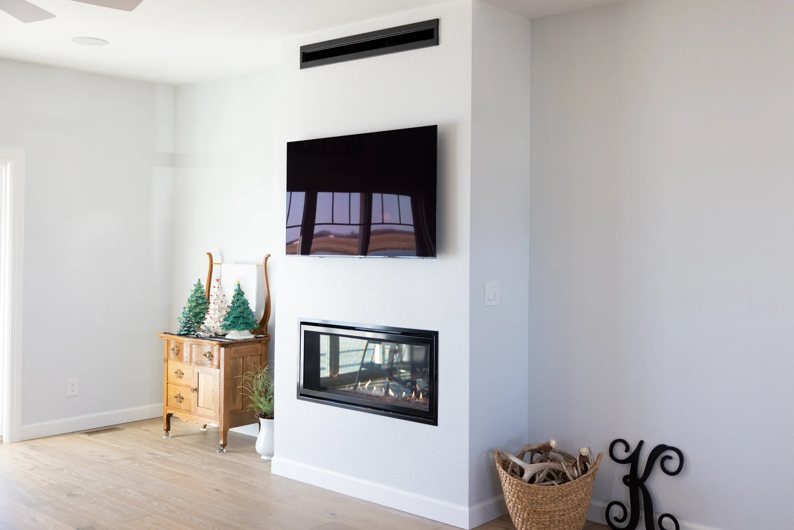 Spacious finished basement family room featuring warm lighting, a modern fireplace, and a built-in wet bar