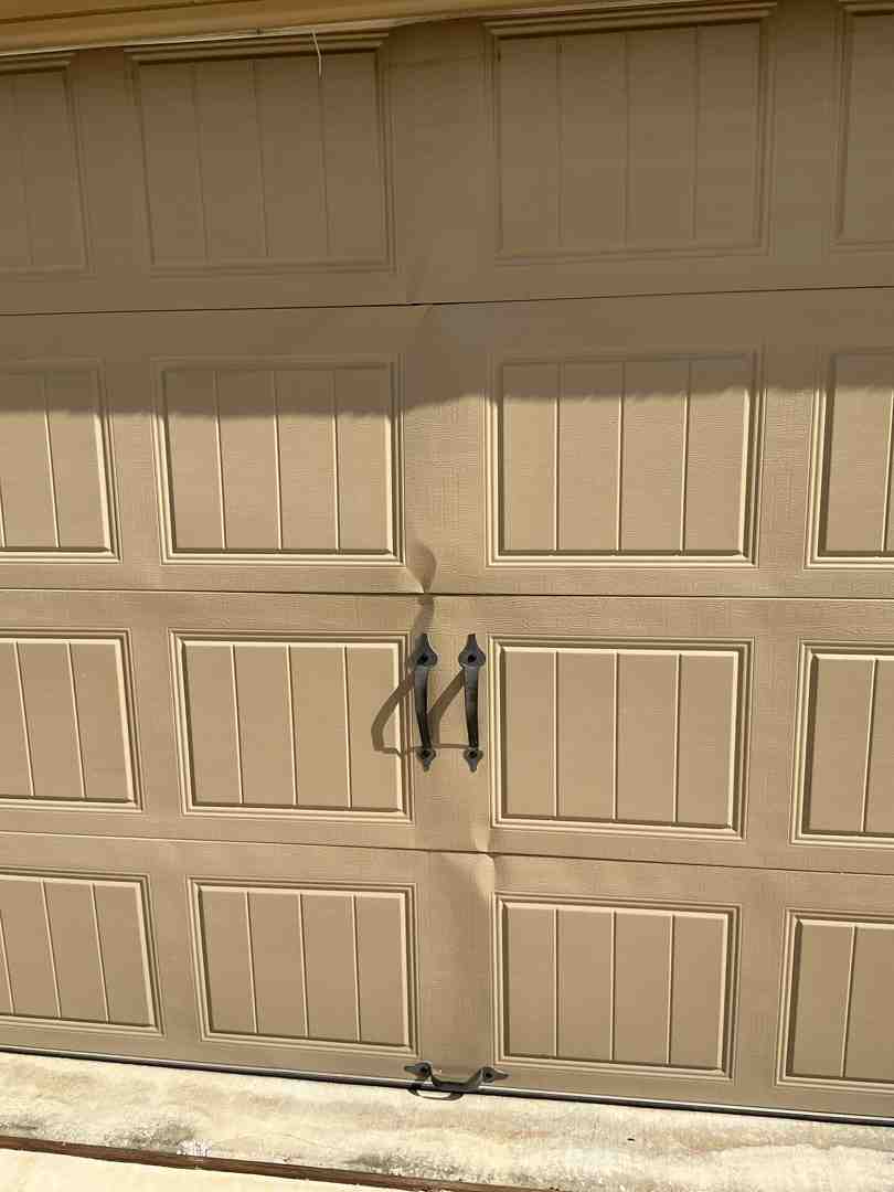Weathered garage door with visible panel damage - Your Search Ends Here: Professional Garage Door Replacement in Bee Caves TX