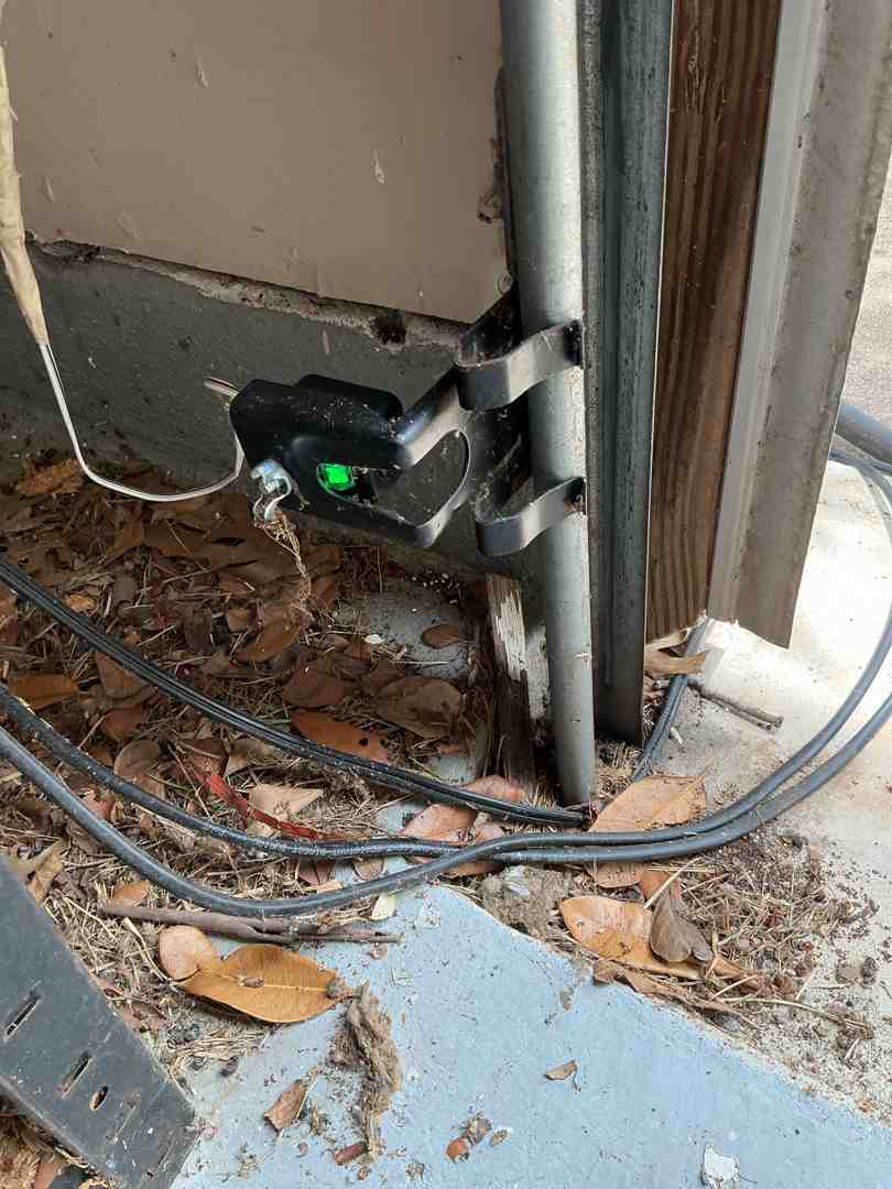 Close-up of garage door safety sensors with green and yellow lights - 