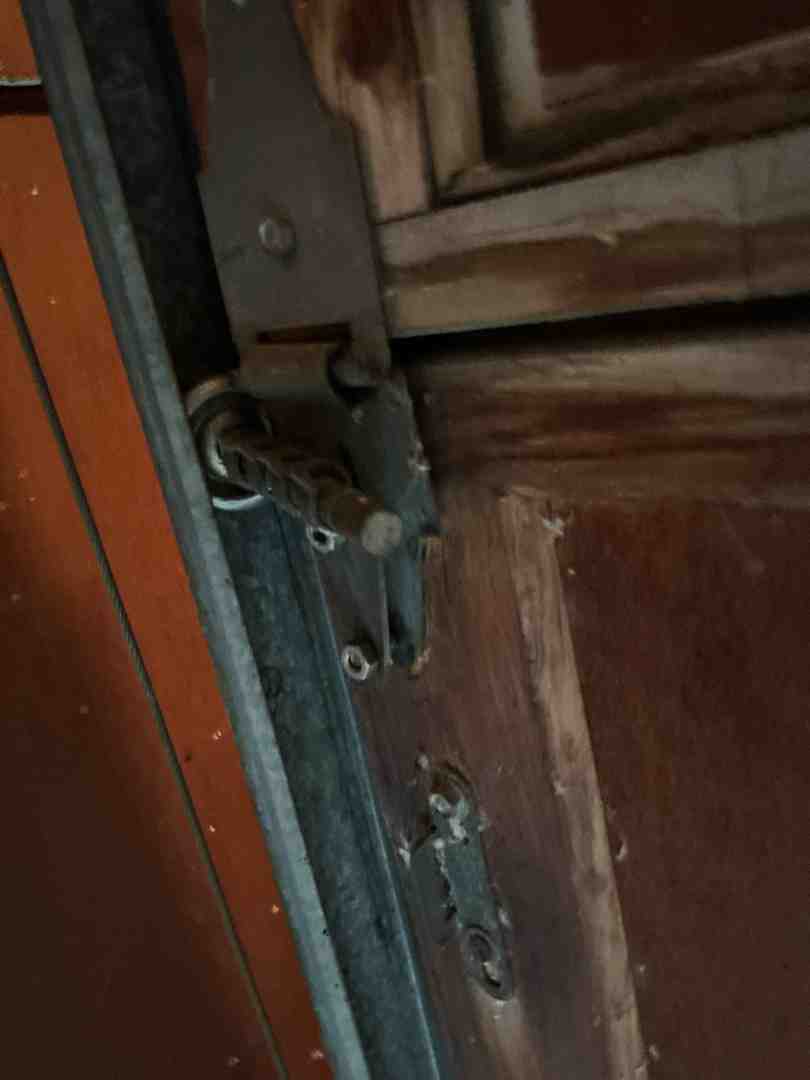 Close-up of a garage door roller that has popped out of the track - "Who Can I Call for Same-Day Garage Door Repair in Austin, TX? My Door Is Off Its Track."