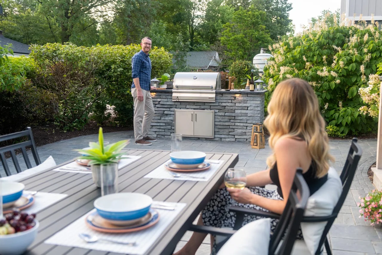 Custom brick patio with outdoor kitchen and seating wall - brick patio garden design