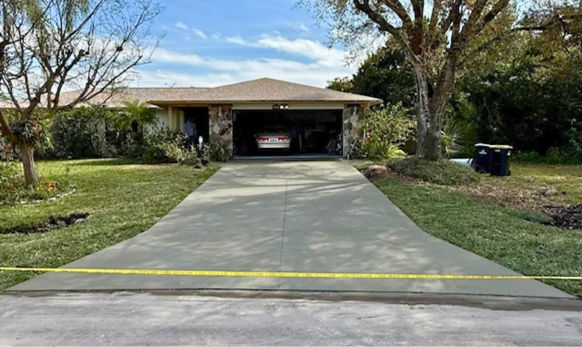 A finished concrete driveway in Palm Bay showing proper drainage
