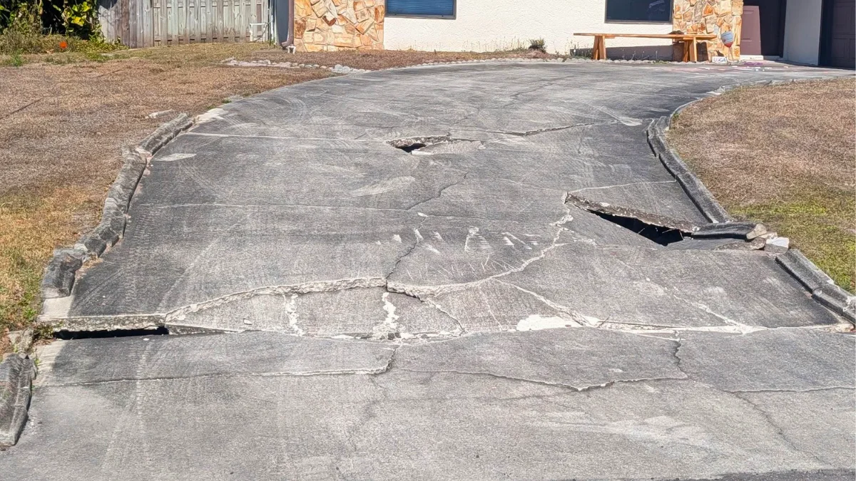 Sunken concrete driveway showing a significant drop near the garage entrance Sunken concrete driveway showing a significant drop near the garage entrance