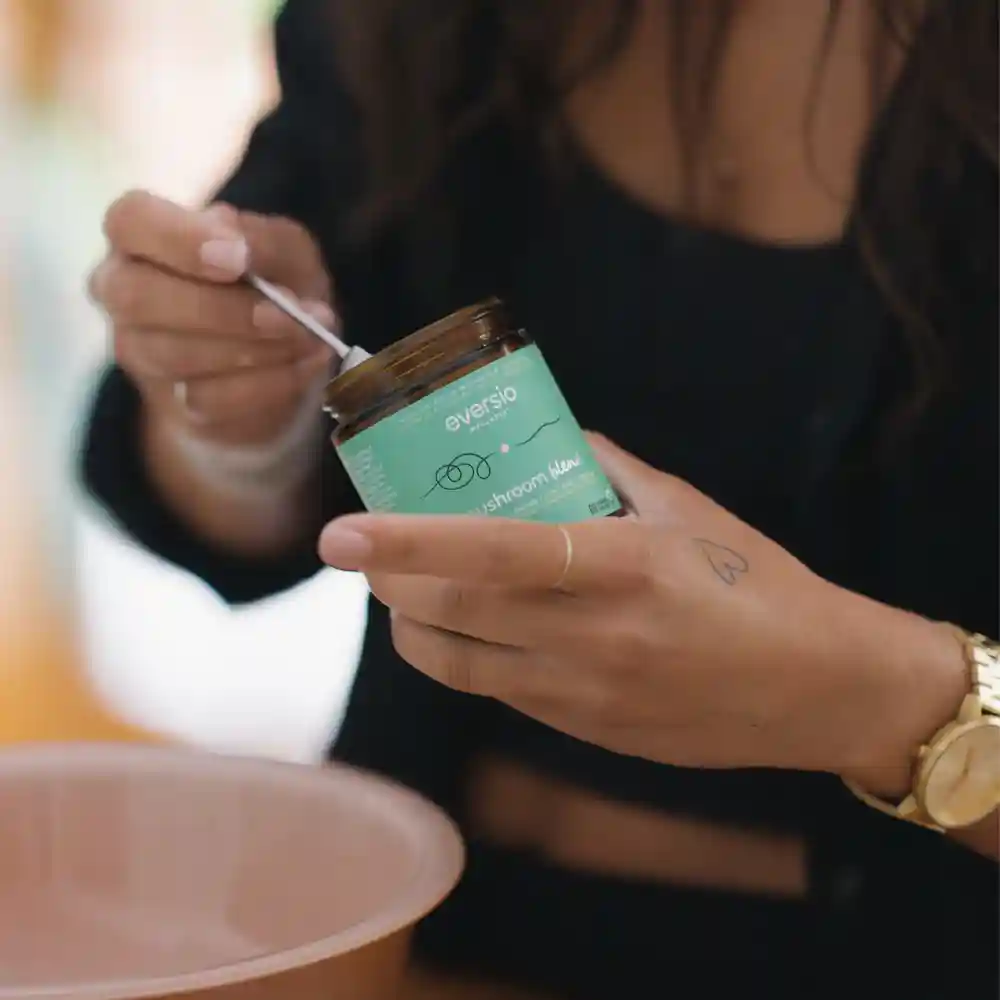 Close-up of a hand preparing a serving of concentrated mushroom blend, highlighting a convenient form of adaptogenic mushroom supplement.
