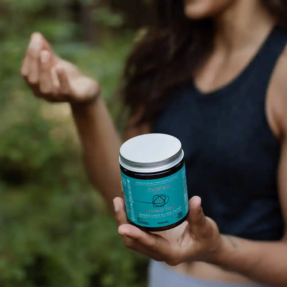 A person holding a jar of Eversio Chaga extract in a forest, promoting wellness through Chaga antioxidant benefits. A person holding a jar of Eversio Chaga extract in a forest, promoting wellness through Chaga antioxidant benefits.