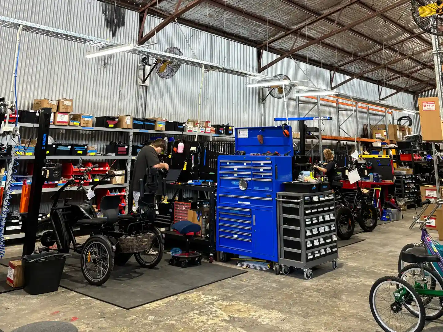 A friendly EveryBody eBikes mechanic adjusting the gears on a customer’s bike in the Brisbane workshop. - bike repairs brisbane cbd
