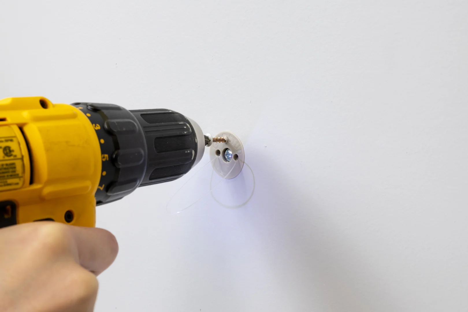 power drill preparing pilot hole in drywall