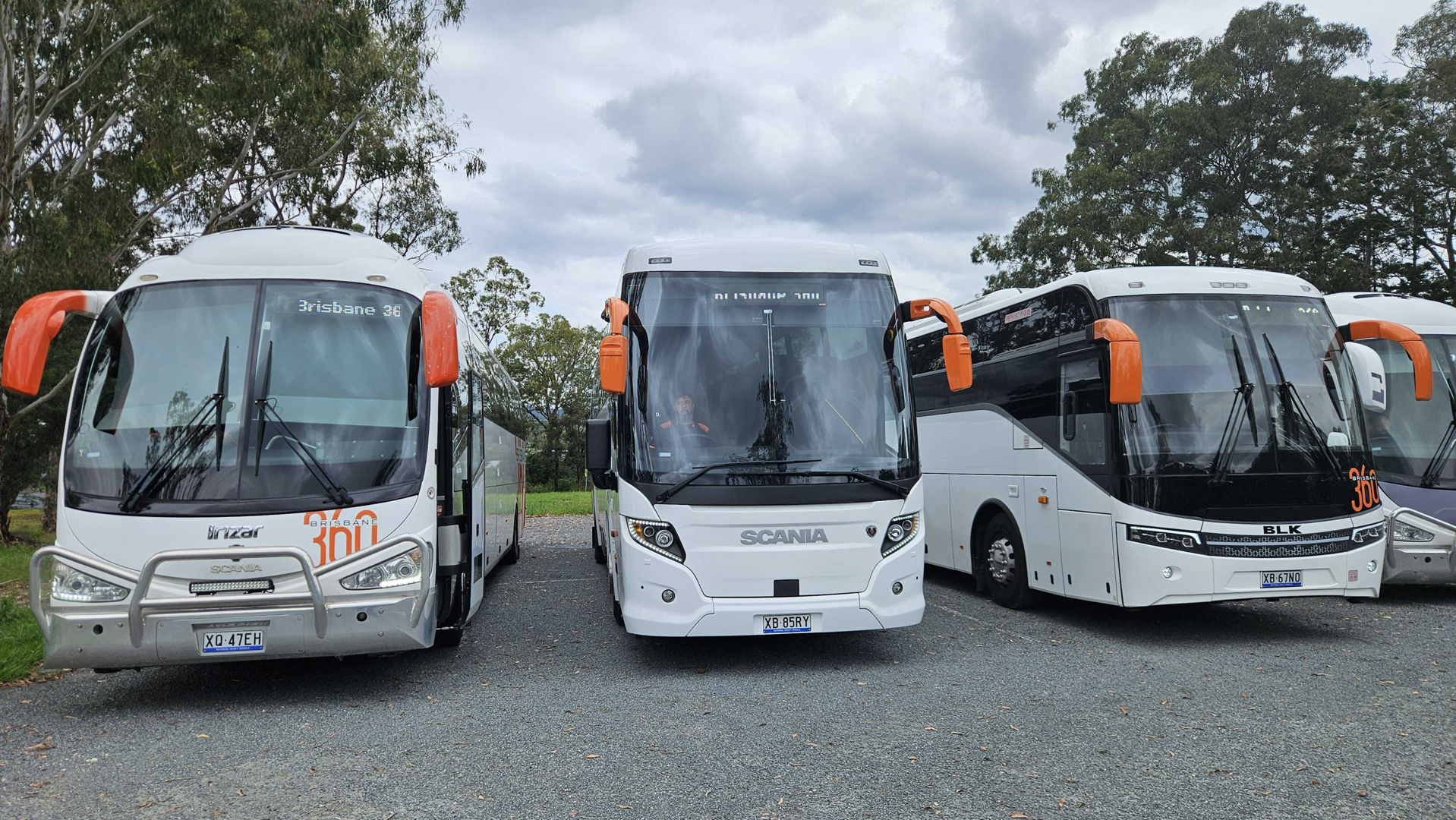 A 57-seat luxury coach parked at the Brisbane Airport terminal ready for passenger boarding - brisbane group transfers