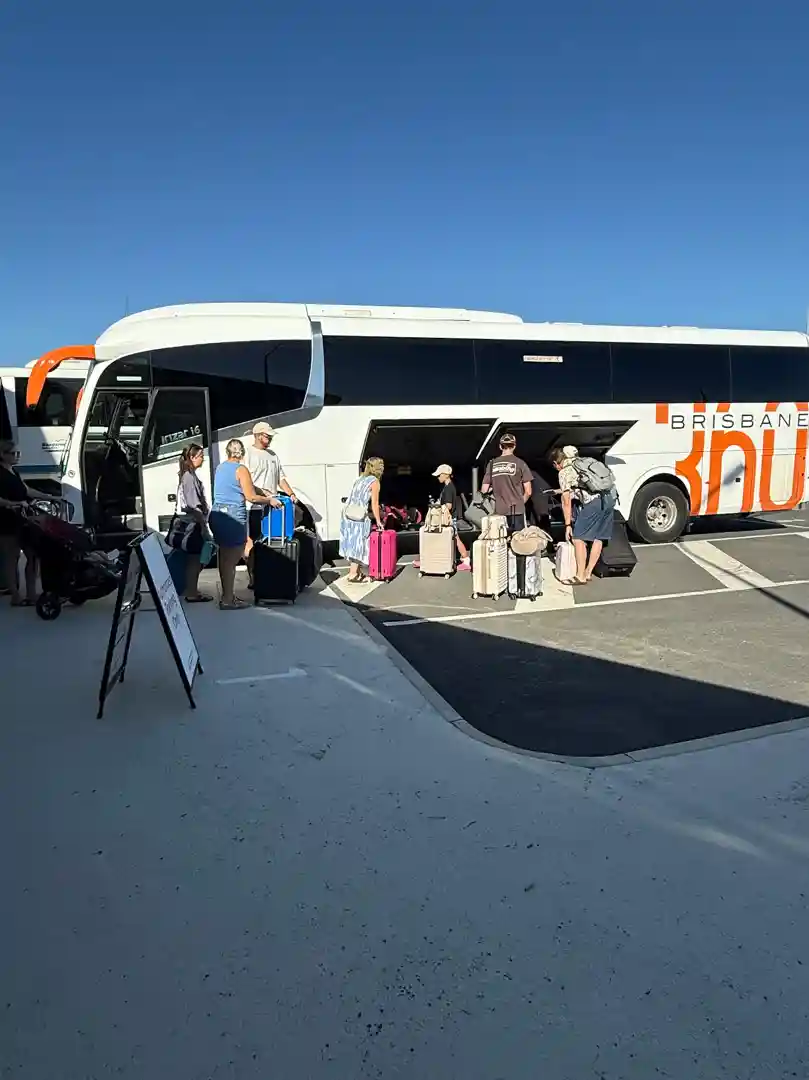 A happy group of travelers boarding a Brisbane360 coach at Brisbane Airport - Long-distance coach hire A happy group of travelers boarding a Brisbane360 coach at Brisbane Airport - Long-distance coach hire