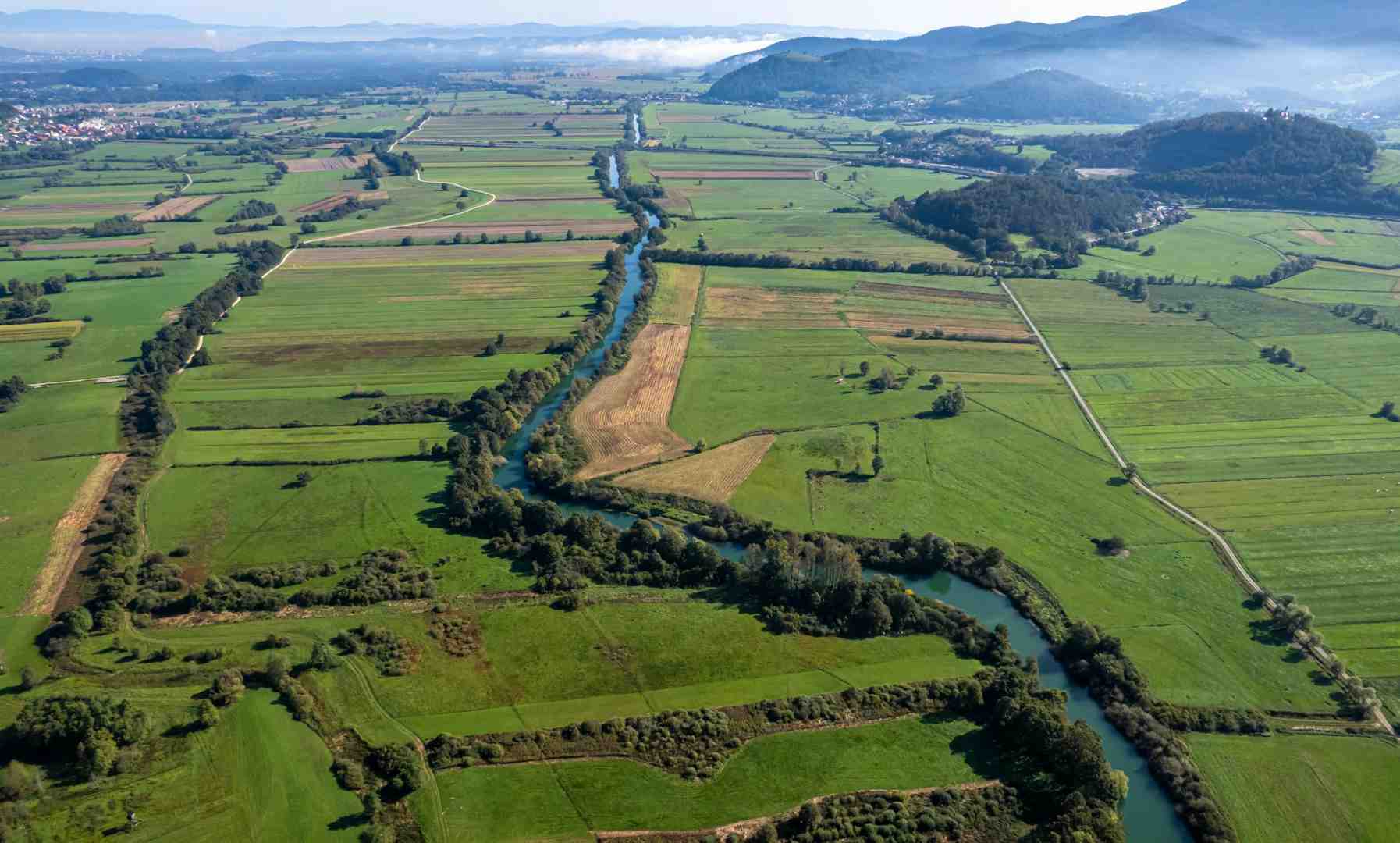 Aerial view of fertile agricultural land with a water source nearby - what to look for when buying agricultural land