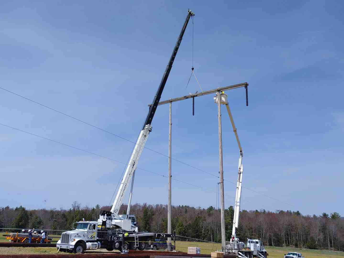 High reach bucket truck performing utility work on high-voltage transmission lines - high reach bucket truck