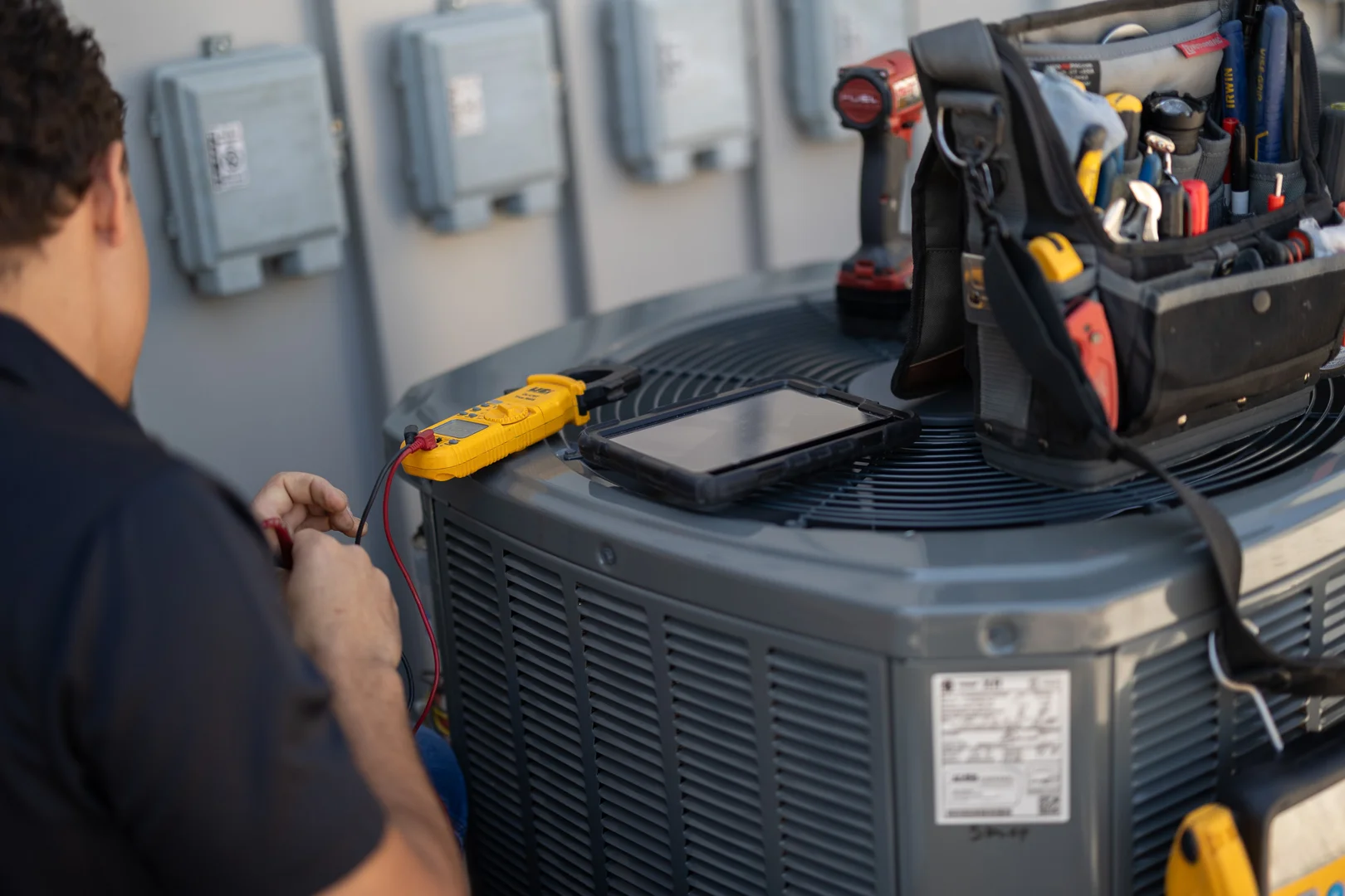 HVAC technician testing electrical contacts