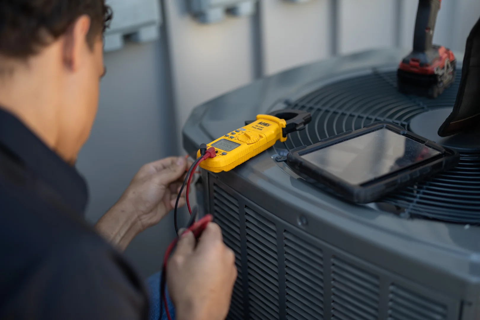 HVAC technician testing furnace electrical components with diagnostic equipment