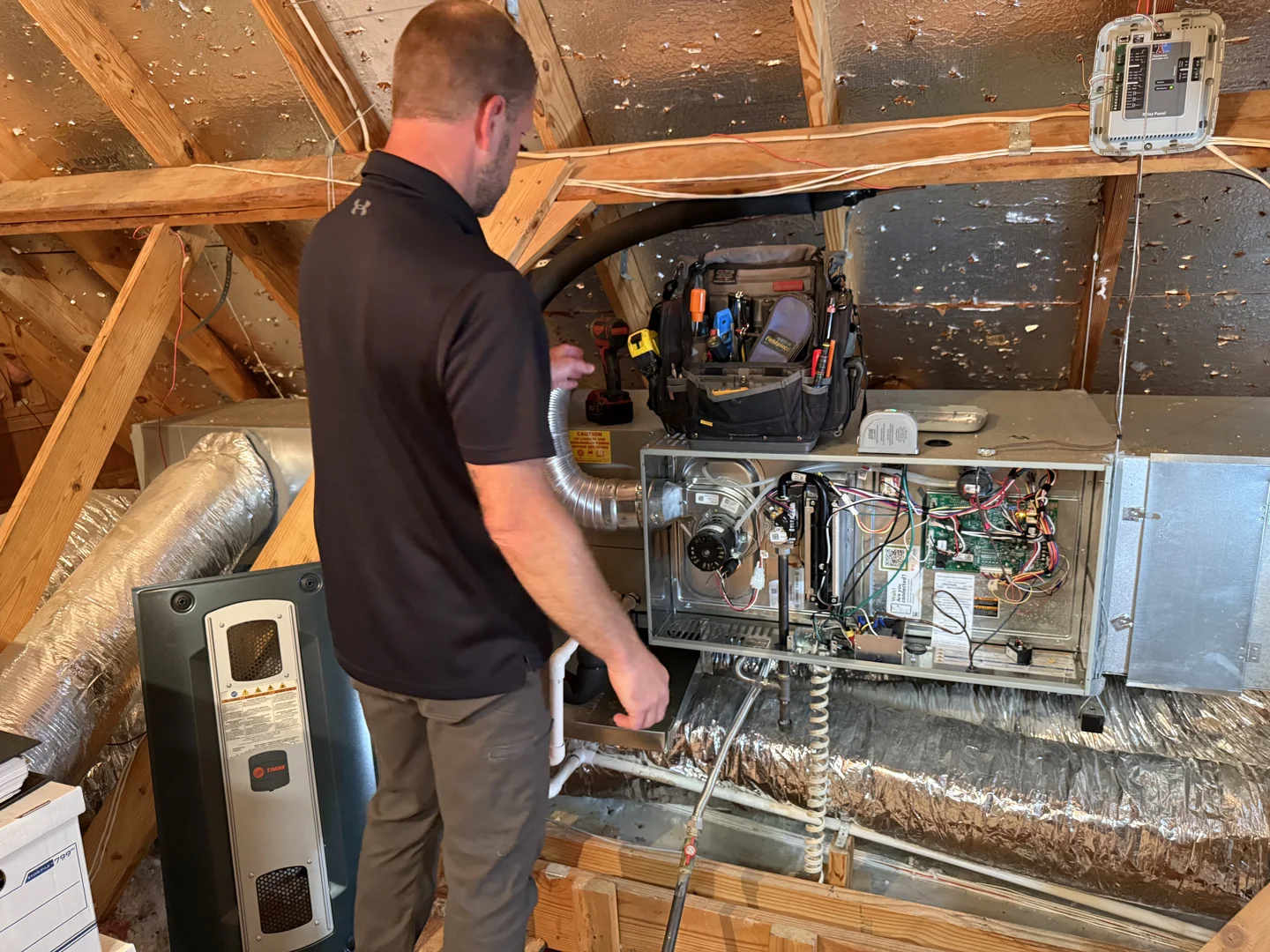 Certified HVAC technician testing a furnace control board and ignition assembly