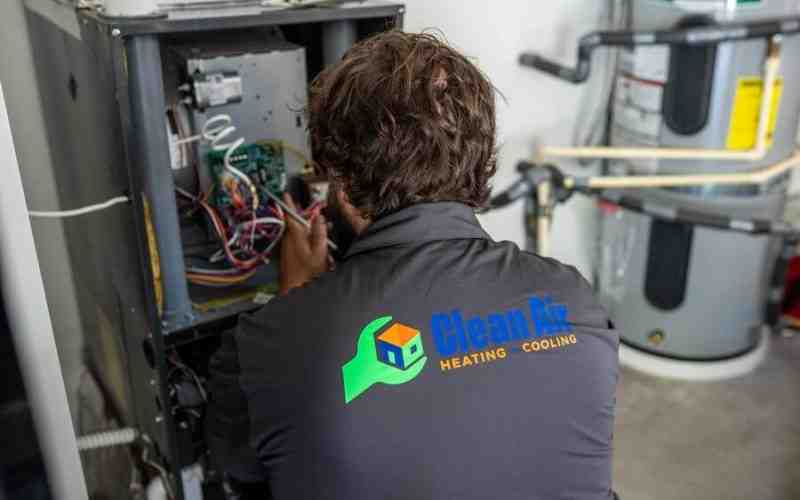 Image of a uniformed technician professionally servicing a commercial furnace - commercial heating service near me