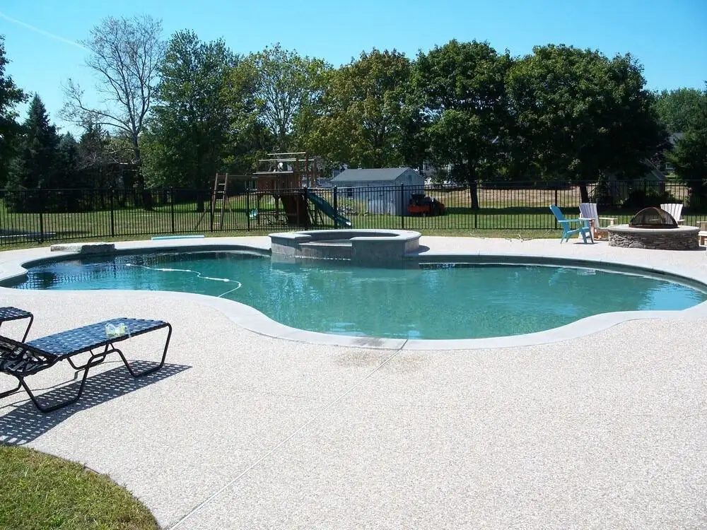 Close-up of gunite being sprayed over a steel rebar frame during construction in a backyard - gunite pools Andover MA Close-up of gunite being sprayed over a steel rebar frame during construction in a backyard - gunite pools Andover MA