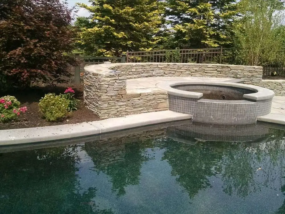 gunite pool with a tanning ledge and integrated spa