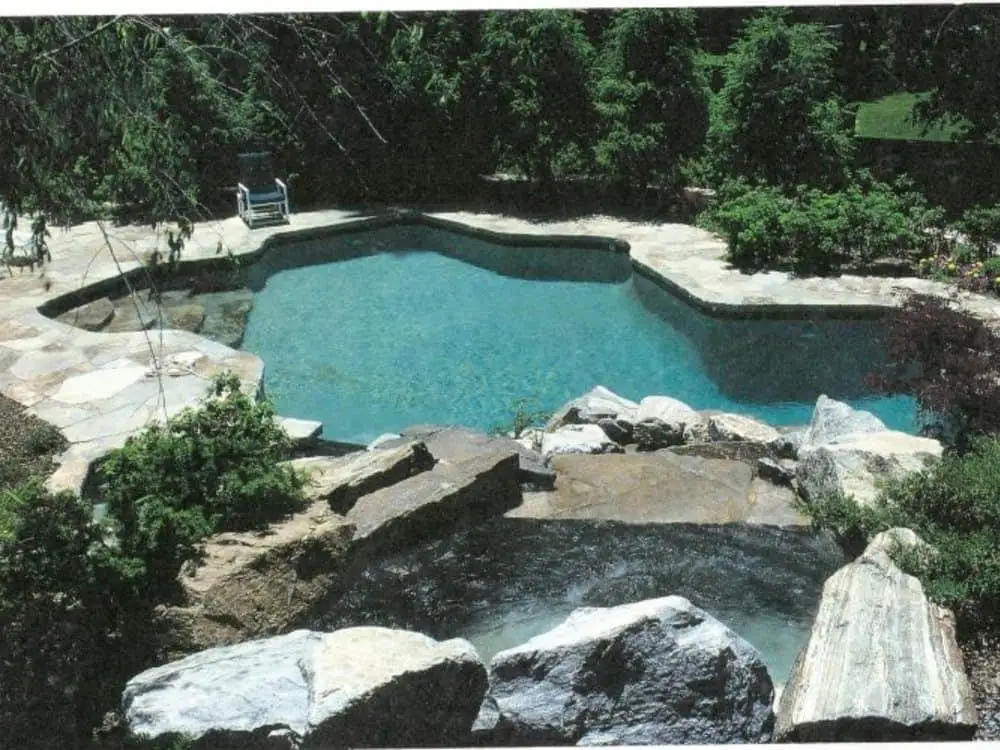 Custom gunite pool with freeform shape and natural stone waterfall - Custom gunite pools