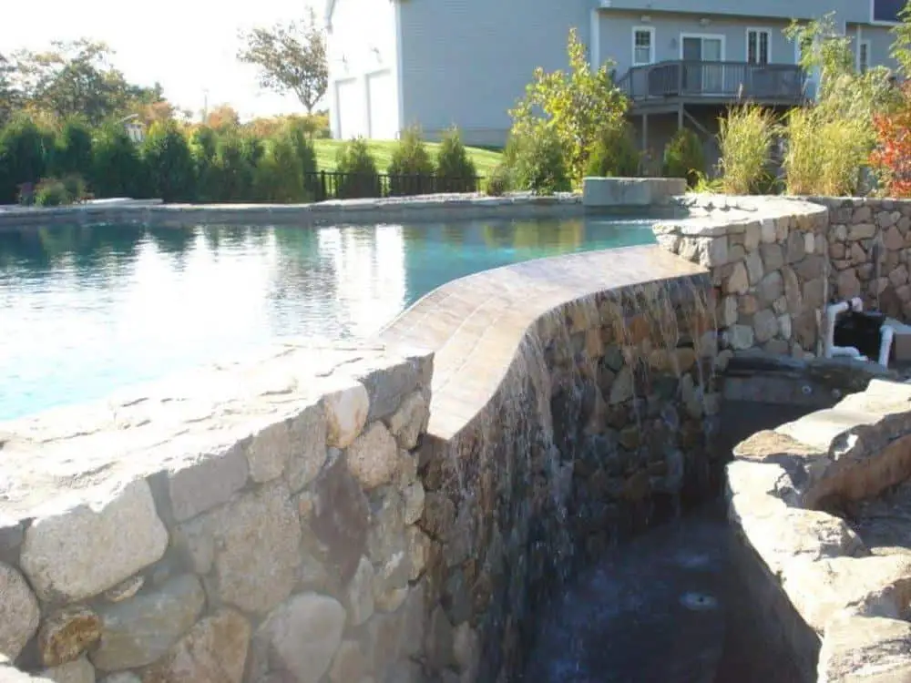 Intricate infinity edge pool design with custom rockwork - gunite construction company