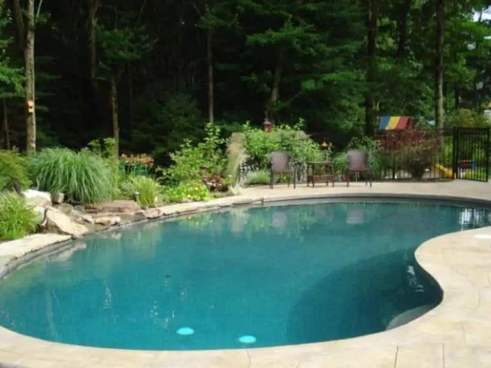 A custom gunite pool nestled in a wooded New Hampshire backyard - average cost of a inground swimming pool