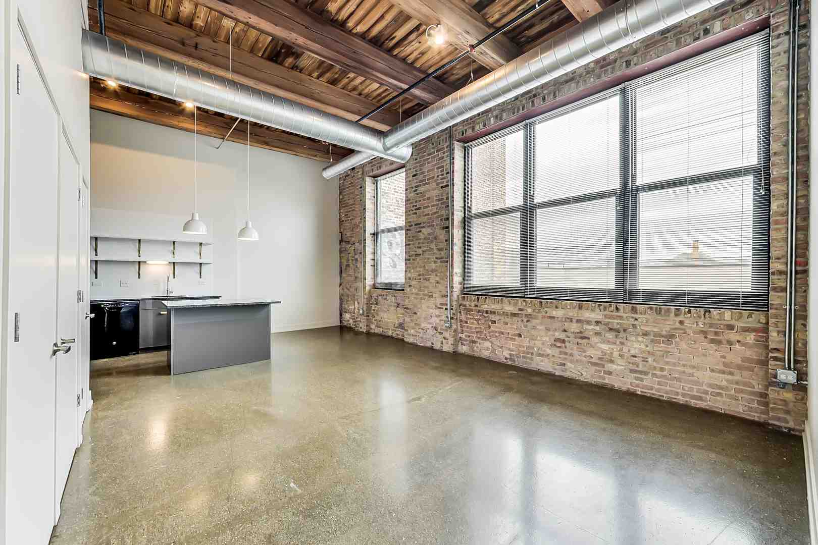 Modern warehouse loft interior featuring exposed brick and timber beams