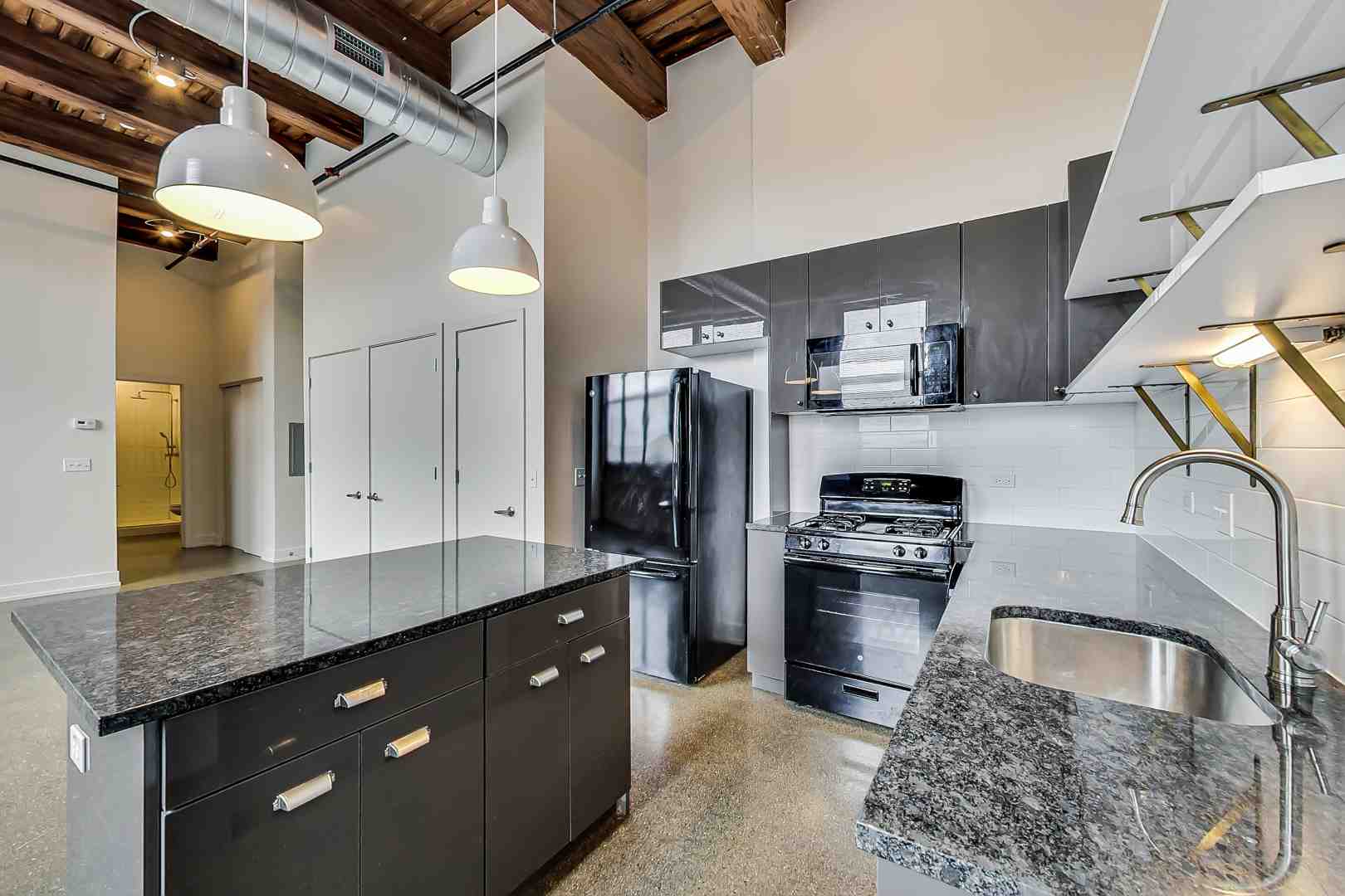 Modern loft kitchen with stainless steel appliances and quartz countertops