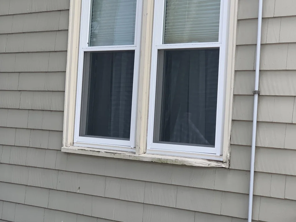 Technician performing wood rot repair on a window sill - Exterior Painting Massachusetts