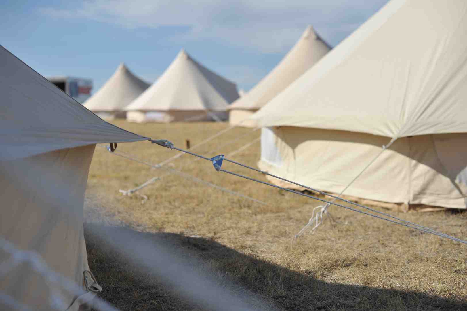 lineup of different sized Stout Bell Tents on platforms - platform tents