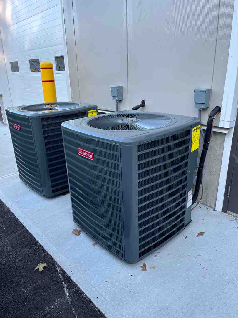 Technician inspecting a large outdoor commercial AC unit - commercial central air conditioner