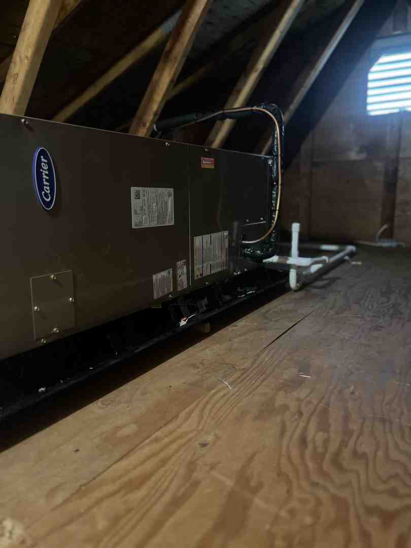 HVAC technician mounting an evaporator coil into a furnace plenum - adding ac to oil furnace