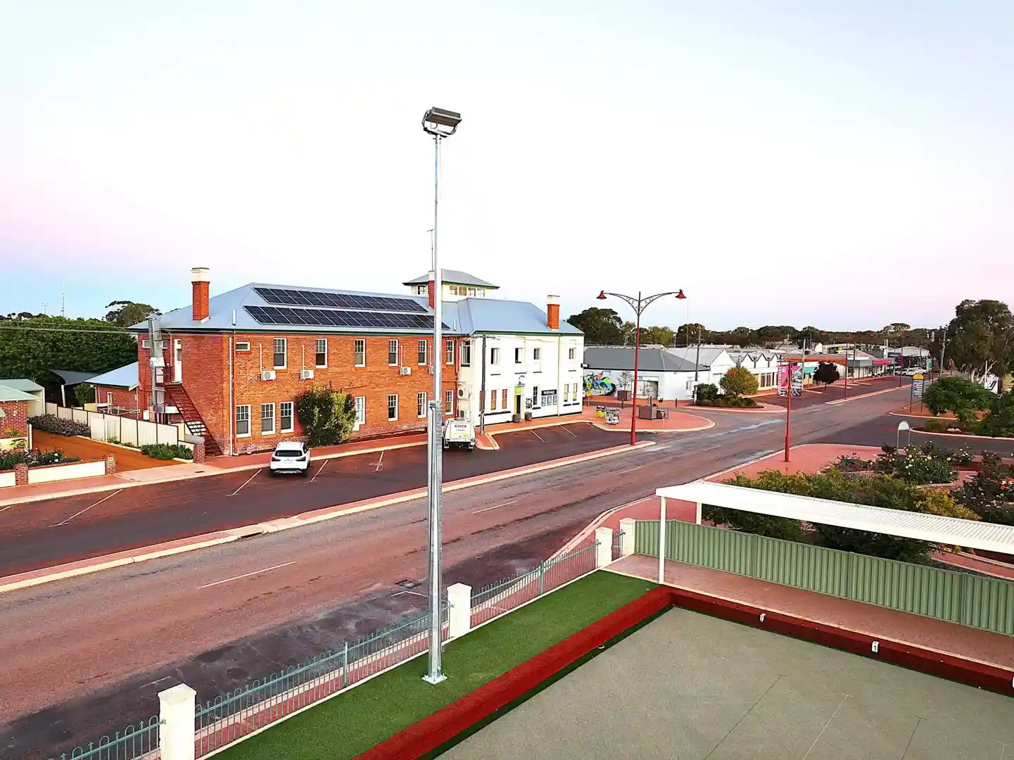 Modern solar-powered street lamp installation in Australian park setting showing solar panels, LED fixtures, and sustainable design elements - commercial street lamps