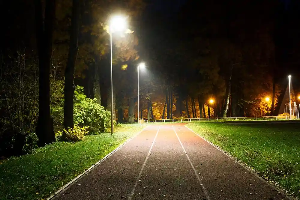 A beautifully lit Australian public park at dusk, with modern LED bollard lights lining a pathway - LED bollard lights Australia