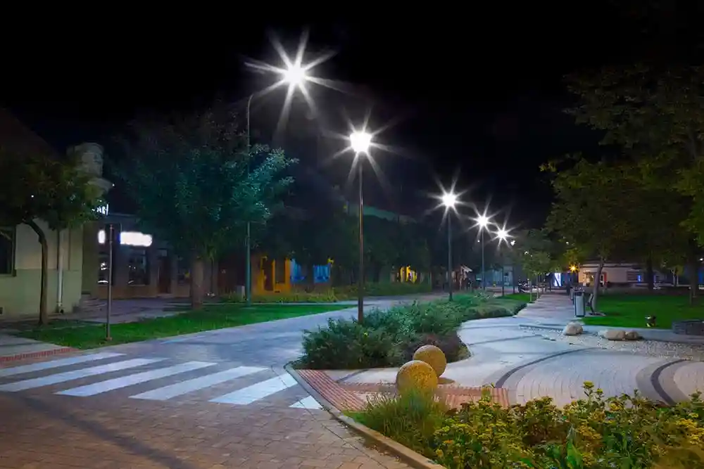 A modern urban precinct with sleek, minimalist decorative poles lining a pedestrian walkway at dusk, casting a warm glow. - outdoor decorative lighting A modern urban precinct with sleek, minimalist decorative poles lining a pedestrian walkway at dusk, casting a warm glow. - outdoor decorative lighting