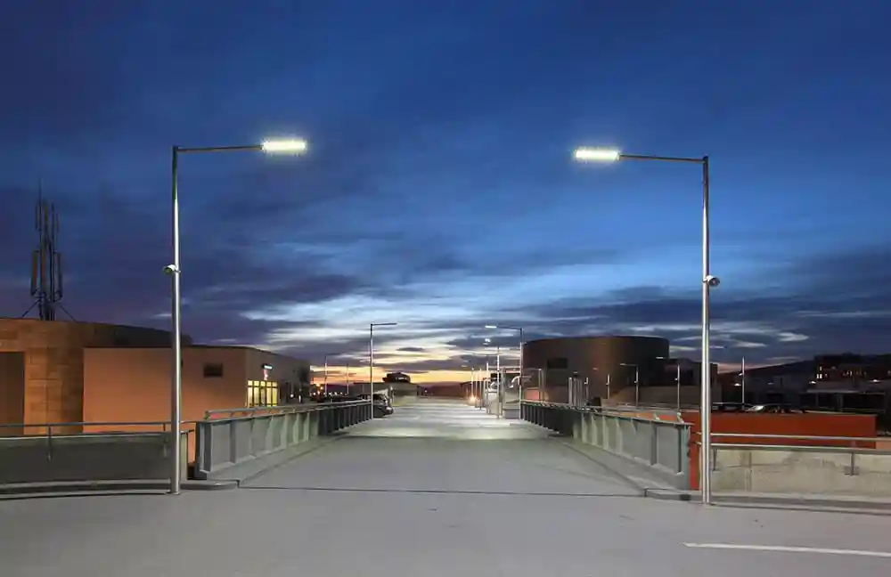 A modern urban street at dusk, showcasing efficient LED roadway lighting illuminating the road and pedestrian areas - LED roadway lighting