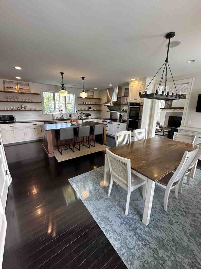 A modern open-concept living room and kitchen with large windows, minimalist furniture, and natural wood accents. - modern house design