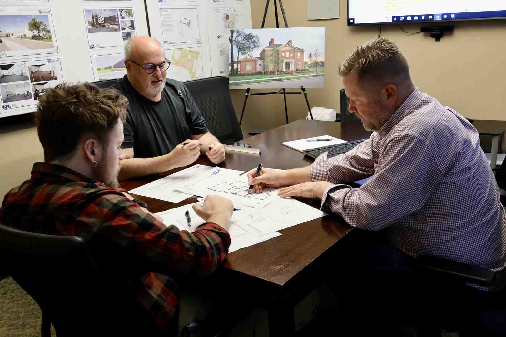 An architect and a couple reviewing design concepts in a bright, modern office - Architectural Planning